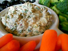 carrots, celery, and black olives on a plate with dip