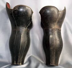 two black vases sitting next to each other on a white cloth