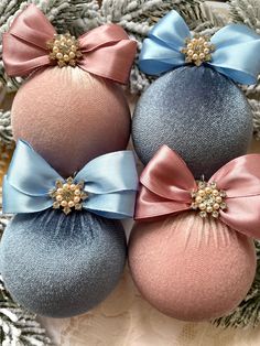 three blue and pink ornaments with bows on them