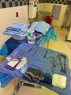 medical supplies are laid out on a table in a hospital room with blue cloths