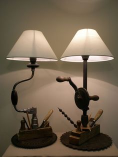 two lamps sitting on top of a table next to each other in front of a white wall