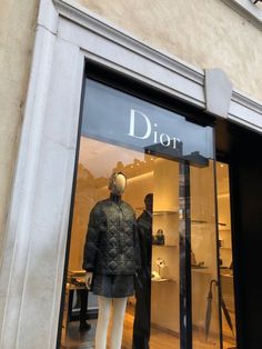 a mannequin in front of a dior store window