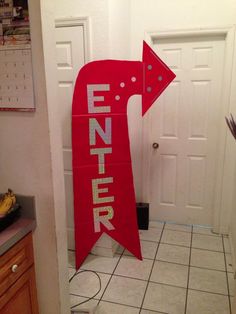 a red sign that says enter with an arrow on it in front of a door