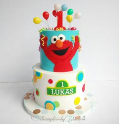 a sesame street birthday cake with the number one on top and balloons in the air