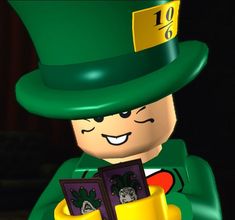 a lego man wearing a green hat and holding a small box with pictures inside it