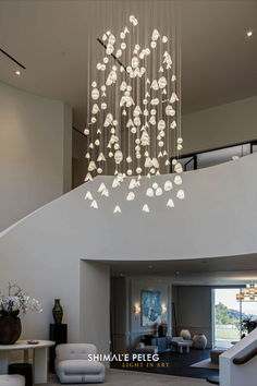 a large chandelier hanging from the ceiling in a living room next to a staircase