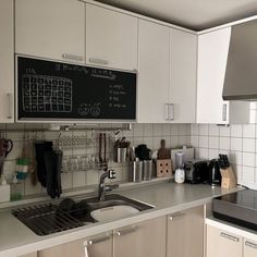 a kitchen with a blackboard on the wall above the sink and counter top area