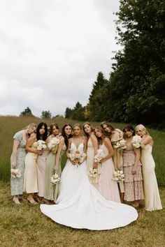 a group of women standing next to each other on top of a grass covered field