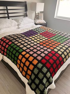 a bed with a colorful blanket on top of it