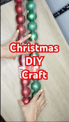 two hands are placing christmas ornaments on a wooden table with the words christmas diy craft