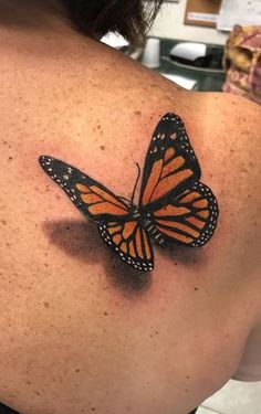 a woman with a butterfly tattoo on her back