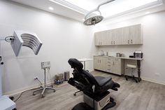 a dentist's office with chairs, lights and cabinets in the room that is empty