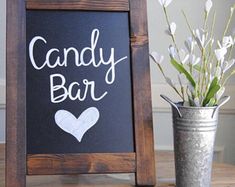 a sign that says candy bar next to a potted plant and vase with flowers