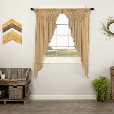 an empty room with a window and wooden furniture