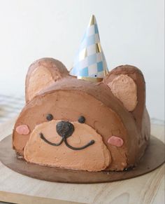 a cake shaped like a bear with a party hat on top