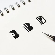 a pen is sitting on top of a spiral notebook with some black and white logos