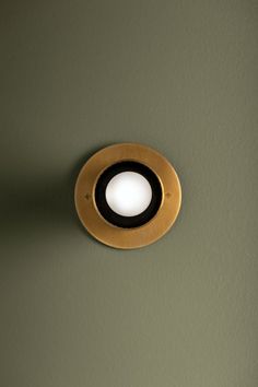 a light that is on the side of a wall in a room with green walls