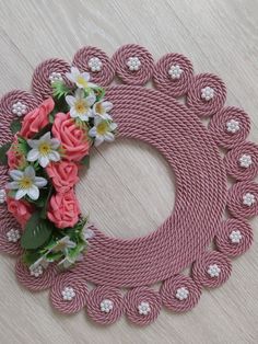 a pink rope wreath with flowers on it