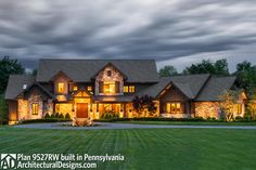 a large house lit up at night with lights on it's windows and landscaping