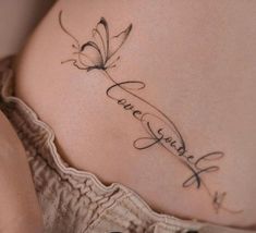 a woman's stomach with a butterfly tattoo on her belly and the word love spelled in cursive writing