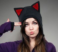 black and white photograph of a woman wearing a cat hat with her hands behind her head