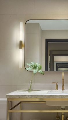 a bathroom sink with a mirror above it and a vase on the counter next to it