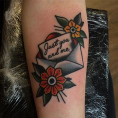 a tattoo with an envelope and flowers on it