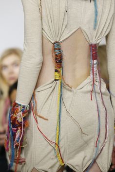 the back of a woman's dress with many strings attached to her butts