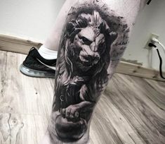 a man's leg with a lion tattoo on it, and the image is black and white