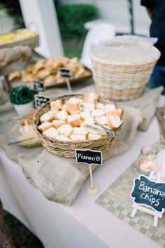 a table topped with lots of food on top of a white table cloth