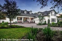 a large white house sitting on top of a lush green field