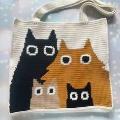 a crocheted bag with three cats on it