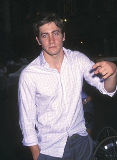 a man pointing at something while wearing a white shirt