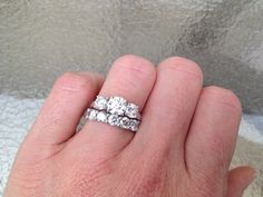 a woman's hand holding two wedding rings