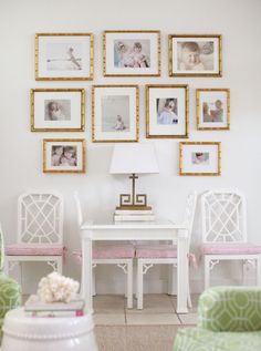 a white table and chairs with pictures on the wall above it in a living room