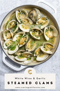 steamed clams with white wine and garlic in a skillet on a gray background