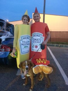 a man and woman in costume standing next to a dog wearing hotdogs costumes