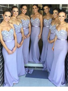 a group of women standing next to each other wearing purple dresses and posing for the camera