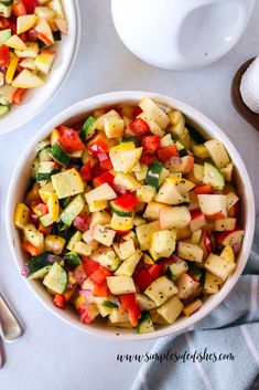 two bowls filled with chopped vegetables next to spoons and utensils on a table