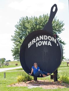 a woman is sitting in a giant frying pan