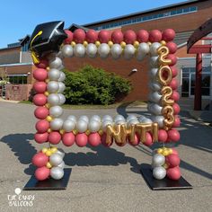 a graduation balloon arch in front of a building