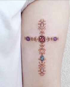 a woman's arm with a cross tattoo on the left side of her body