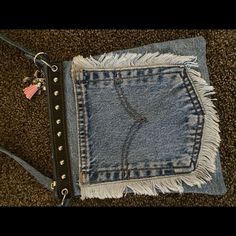 an old pair of jeans with studded details and fringes on the bottom are sitting on carpet