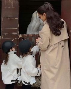 a woman and two small children wearing helmets