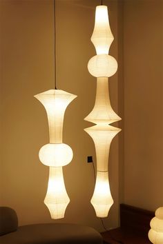 three white lamps hanging from the ceiling in a room with beige walls and flooring