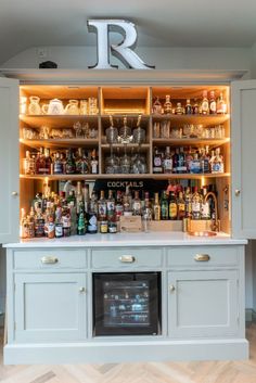 a bar with lots of bottles and glasses on the top shelf in front of it