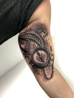 a man with a compass tattoo on his arm