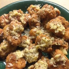 a green plate topped with meatballs covered in sauce