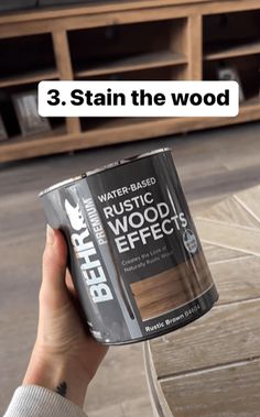 a person holding a can of stain the wood