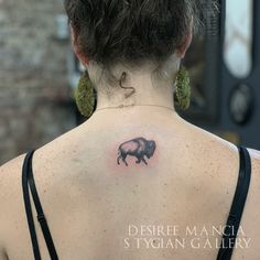 the back of a woman's neck with a pig tattoo on it